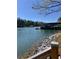 Lakefront property featuring a covered dock with multiple boat slips and a rocky shoreline at 3560 Chattahoochee Rd, Cumming, GA 30041