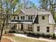 Beautiful two-story home showcasing white siding, a covered front porch, and lush surroundings at 3560 Chattahoochee Rd, Cumming, GA 30041