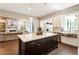 Open-concept kitchen with large island, stainless steel sink, and view of living room at 3560 Chattahoochee Rd, Cumming, GA 30041