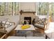 Inviting sunroom with fireplace, comfortable seating, and surrounded by peaceful wooded views at 3560 Chattahoochee Rd, Cumming, GA 30041