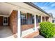 Covered porch with white columns and brick railing at 6355 Valhalla Dr, Douglasville, GA 30135