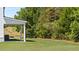View of the backyard featuring a covered patio and green lawn at 640 Kimberwick Dr, Locust Grove, GA 30248