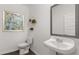 Cozy powder room featuring a wall-mounted sink, decorative mirror, and artistic accents for a touch of elegance at 640 Kimberwick Dr, Locust Grove, GA 30248