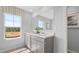 Bright bathroom featuring double sinks, a large mirror, and a view of the outside at 640 Kimberwick Dr, Locust Grove, GA 30248