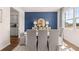 Stylish dining room with navy accent wall, lamps, mirror and seating for six at 640 Kimberwick Dr, Locust Grove, GA 30248
