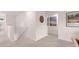 Upstairs hallway with neutral carpet, white walls, and decorative wall art, leading to various rooms at 640 Kimberwick Dr, Locust Grove, GA 30248