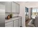 Kitchenette with light gray cabinets and countertops, next to a dining space featuring a large window at 640 Kimberwick Dr, Locust Grove, GA 30248
