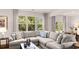 Cozy living room featuring a sectional sofa, large windows, and neutral color palette at 640 Kimberwick Dr, Locust Grove, GA 30248