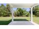 Covered patio with white columns overlooking the backyard with green lawn and trees at 640 Kimberwick Dr, Locust Grove, GA 30248