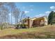 Spacious backyard with a view of the home's exterior and surrounding landscape at 9975 Holly Hill Way, Jonesboro, GA 30238