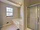 Bathroom featuring a jacuzzi tub with window and walk-in shower at 2099 Winsburg Nw Way, Kennesaw, GA 30144