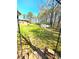 View of a large backyard with room for parking, and a backdrop of mature trees at 2958 Klondike Rd, Lithonia, GA 30038