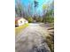 Long driveway leading to home and separate structure, surrounded by mature trees at 2958 Klondike Rd, Lithonia, GA 30038