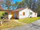 Quaint one-story home with white siding, bright orange trim, and a yellow door with matching stairs at 2958 Klondike Rd, Lithonia, GA 30038