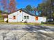Charming one-story home with a white exterior, orange trim, and a neatly maintained front yard at 2958 Klondike Rd, Lithonia, GA 30038