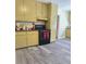 Well-lit kitchen featuring gray floors, olive green cabinets, a black countertop, and a black gas range at 2958 Klondike Rd, Lithonia, GA 30038