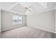 Well-lit primary bedroom featuring a decorative tray ceiling and soft carpet at 3313 Summit Creek Ln, Loganville, GA 30052