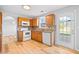 Well-lit kitchen with light wood cabinets, granite countertops, and modern white appliances at 3313 Summit Creek Ln, Loganville, GA 30052