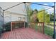 View of the wooden deck inside metal pergola with trees and the exterior of the home in the background at 3313 Summit Creek Ln, Loganville, GA 30052