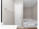 Bathroom featuring a corner soaking tub, neutral walls, and access to other areas at 6405 Grafton Dr, Austell, GA 30168