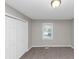 Carpeted bedroom featuring a window and closet with bi-fold doors at 6405 Grafton Dr, Austell, GA 30168