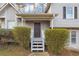 Close-up of the home's front entrance, featuring a covered porch, gray door, and decorative shrubs at 6405 Grafton Dr, Austell, GA 30168