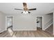 Well-lit living room showcasing wood-look floors, gray walls, ceiling fan, and access to the kitchen and stairs at 6405 Grafton Dr, Austell, GA 30168