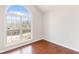 Bedroom with hardwood floors and a large arched window showcasing the view at 7806 Poppy Seed Pl, Winston, GA 30187