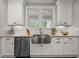 Bright kitchen featuring white cabinets, subway tile backsplash, stainless steel appliances, and a farmhouse sink at 2317 Pleasant Grove Rd, Temple, GA 30179