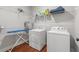 This laundry room features a washer, dryer, shelving, ironing board, and ample storage space at 2317 Pleasant Grove Rd, Temple, GA 30179