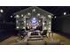 Outdoor living area with string lights, fireplace, and comfortable seating at 2317 Pleasant Grove Rd, Temple, GA 30179