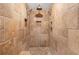 A stand-up shower tiled with beautiful travertine, features two shower heads and a built-in seat and niche at 746 Amsterdam Ave, Atlanta, GA 30306