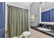 Bathroom featuring a shower with curtain, toilet, vanity with dark countertop, and a neutral color scheme at 8303 Santa Fe Pkwy, Atlanta, GA 30350