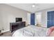 Comfortable bedroom showcases a neutral color scheme, TV, and two stylish blue doors leading to other rooms at 8303 Santa Fe Pkwy, Atlanta, GA 30350