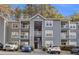Gray multi-story apartment building complex featuring balconies and well-maintained landscaping at 8303 Santa Fe Pkwy, Atlanta, GA 30350