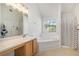 Bright bathroom with a soaking tub under the window, a shower, and ample counter space at 1297 Partridge Ln, Riverdale, GA 30296