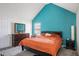 Bright bedroom with an orange bedspread, a large dresser with a mirror, and a serene turquoise accent wall at 1297 Partridge Ln, Riverdale, GA 30296
