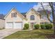 Traditional two-story home with a manicured front lawn, a two-car garage, and a welcoming facade at 1297 Partridge Ln, Riverdale, GA 30296