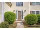 Inviting front entrance with a wood door, manicured bushes, and decorative exterior lighting fixtures at 1297 Partridge Ln, Riverdale, GA 30296