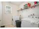 Practical laundry room with modern appliances and shelving for storage at 1297 Partridge Ln, Riverdale, GA 30296