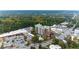 Expansive aerial view captures a brick apartment building, stores, roads, and many parking lots in lush area at 3820 Roswell Ne Rd # 902, Atlanta, GA 30342