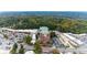 A dynamic aerial shot features a brick apartment building, nearby stores, and street lined with green trees at 3820 Roswell Ne Rd # 902, Atlanta, GA 30342