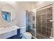Bathroom featuring a stylish vanity with sink and walk-in shower with glass doors and sleek dark tiling at 3820 Roswell Ne Rd # 902, Atlanta, GA 30342
