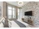 Bedroom featuring a stone accent wall, large window, balcony access, and contemporary ceiling fan at 3820 Roswell Ne Rd # 902, Atlanta, GA 30342