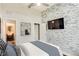 Modern bedroom featuring stone accent wall, ceiling fan, and closet with an adjoining bathroom at 3820 Roswell Ne Rd # 902, Atlanta, GA 30342