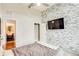 Bedroom featuring a stone accent wall, closet, and ensuite bathroom with wood flooring in entrance at 3820 Roswell Ne Rd # 902, Atlanta, GA 30342
