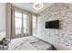 Bedroom with large windows, access to a balcony, stone accent wall, ceiling fan, and carpet at 3820 Roswell Ne Rd # 902, Atlanta, GA 30342