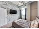 Cozy bedroom with a stone accent wall, a ceiling fan, and a door to a balcony to enjoy the views at 3820 Roswell Ne Rd # 902, Atlanta, GA 30342