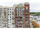 Tall brick apartment building with many balconies, with lush trees nearby with shops in the foreground at 3820 Roswell Ne Rd # 902, Atlanta, GA 30342