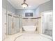 Luxurious bathroom featuring a soaking tub, glass shower, and tile flooring at 3036 Lassiter Rd, Marietta, GA 30062